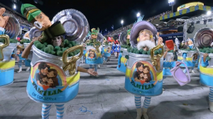 Integrantes da Acadêmicos de Niterói desfilam com fantasias de latas de conserva com a ilustração de uma família tradicional e o texto 'Família em Conserva