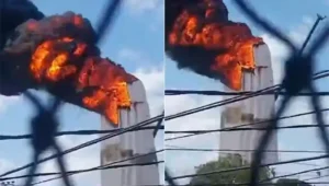 Densa nuvem de fumaça preta saindo de uma estrutura metálica de 35 metros em chamas; imagem ilustra o incêndio da estátua de Nossa Senhora de Fátima em Natal