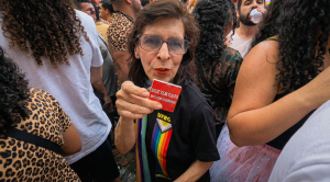 Reitora da UFRGS, segura um adesivo vermelho com slogan sexual durante o Carnaval