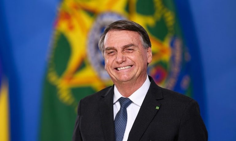 O senador Flávio Bolsonaro em entrevista no Aeroporto de Brasília; imagem ilustra a matéria sobre as declarações a respeito do financiamento do filme Dark Horse em maio de 2026.