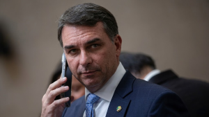 O senador Flávio Bolsonaro prestando esclarecimentos à imprensa; a imagem ilustra a matéria sobre a defesa do financiamento do filme Dark Horse em maio de 2026.