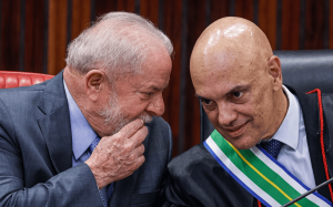 Presidente Lula e o ministro Alexandre de Moraes conversando ao pé do ouvido durante solenidade oficial em Brasília.